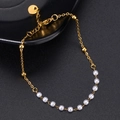 Elegante bracciale con perle dorate e piccole perle bianche su una catena sottile - Stile Perla Dorata