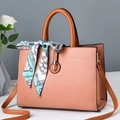 Pink faux leather tote bag with brown handles and a blue patterned silk scarf accessory - Pink