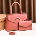 Detail of coral pink lychee textured leather handbags with gold hardware and shoulder strap - Pink