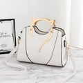 White handbag with golden cat-shaped metal handle and black outline detailing - White