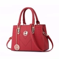 Dettaglio della borsa rossa in ecopelle con cuciture a V e ciondolo logo M dorato lucido - Rosso