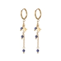Detailopname van 14K vergulde kwastoorbellen met sterhanger en blauwe lapis lazuli kralen - Blauw