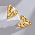 Pendientes de corazón dorado con textura de lava sobre un pedestal de piedra blanca - Dorado