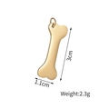 Macro shot of gold bone-shaped pendant with dimensions 3cm by 1.1cm and 2.3g weight - Bone Pendant / Gold