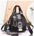 Close-up of black leather backpack with size 21cm, star pendant and striped shoulder strap - Black
