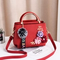 Red lychee pattern handbag with 3D floral accents and gold semi-circular handles - Red