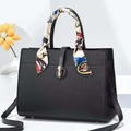 Détail d'un sac à main noir en cuir grainé avec poignée foulard et fermoir doré - Noir