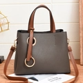 Chic two-tone bucket bag in dark grey and brown pebbled leather with gold ring accents - Gray