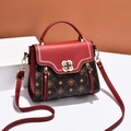 Red and brown patchwork crossbody bag with monogram pattern and floral metal buckle - Red