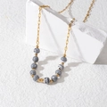 Minimalistische gouden ketting met zwart-wit gestreepte kralen op geometrische stenen - Zwart & Wit Macaron Kralen Ketting