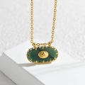 Collar con colgante ovalado de circón verde y estrella en acero inoxidable dorado sobre piedra - verde oscuro
