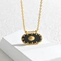 Collar ovalado dorado con incrustación negra y dije de estrella en bloque blanco - Negro