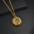 Primer plano de collar con relicario de girasol dorado sobre cuero negro elegante - Dorado