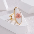 Macro detail of oval gold ring featuring real orange dried flower in white resin base - Adjustable Open / Oval White Style