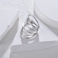 Minimalist multi-layer spiral ring in silver finish on white geometric stand - Adjustable Open / Silver