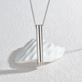 Collana con pendente a fischietto cilindrico in argento lucido su supporto bianco moderno - Stile fischietto cilindrico argento