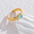 Verstelbare gouden gedraaide ring met ovale blauwe zirkoon op een stenen ondergrond - Meerblauwe Ovale Zirkoon Ring