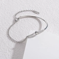 Minimalistisches Edelstahlarmband in Silber mit Zirkon auf weißem geometrischem Ständer - Stahlfarbe