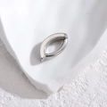 Polished silver stainless steel hinged belly button ring on white textured stone - Steel