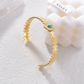 Dettaglio del bracciale vintage dorato con pietra turchese e motivi a foglia - Stile Foglia di Turchese (B953)