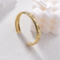 Bracciale rigido aperto dorato con motivi malocchio e bordi zigrinati su base bianca - Stile Occhio del Diavolo (B952)
