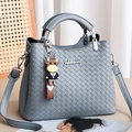 Gray woven leather handbag with silver hardware and a cute cartoon cow charm pendant - Blue