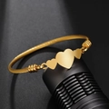 Gold twisted rope cuff bracelet with three polished heart charms in minimalist style - Gold