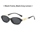 Gafas de sol ovaladas retro con montura negra, lentes grisáceas y detalle de metal dorado - Montura Negra Lentes Gris Negro