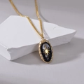 Minimalistische 14K Goldhalskette mit schwarzem Emaille-Sternanhänger auf weißem Stein - Schwarzer Ovaler Stern