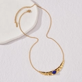 Collana a mezzaluna dorata con trama martellata e pietra blu ovale incastonata - Stile Mezzaluna d'Oro con Gemma Blu