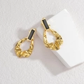Gold oval stud earrings with black gemstone and wavy fluid metal ring on white stone - Gold with Black
