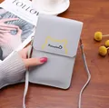 Détail d'une pochette tactile grise pour téléphone tenue à la main sur un bureau - Gris clair