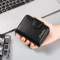 Detalle de cartera negra para hombre en cuero con cremallera, botón de presión y logo oro - Negro