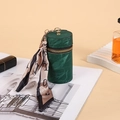 Dark green cylindrical coin purse with suede finish, golden zipper and silk scarf detail - Green