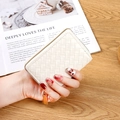 White woven leather zipper wallet and accordion card holder for women on wooden desk - White