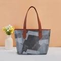 Vintage grijze patchwork leren shopper met bruine hengsels op een minimalistische achtergrond - Grijs Geometrisch Patchwork (Zwart)