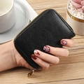 Hand holding a black litchi pattern PU leather card holder with gold zipper detail - Black