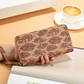 Lange Kork-Brieftasche mit buntem Federdruck und Handschlaufe in der Hand gehalten - Stil 1 Federmuster