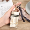 Estuche cilíndrico para pintalabios en cuero beige con estampado floral vintage - Marrón