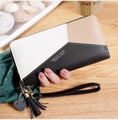 Detail of long contrast color zipper wallet with tassel and rabbit charm in hand - Black