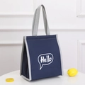 Navy blue insulated lunch bag with grey trim and Hello print on a white table - Blue