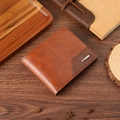 Portefeuille pour homme en cuir marron avec surpiqûres sur fond bois rustique - Fauve