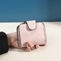 Portefeuille court rose mat avec fermeture à pression tenu délicatement à la main - Rose Clair