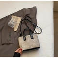 Dettaglio della borsa a secchiello bicolore in tessuto grigio e manici in pelle nera - Beige e nero