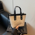 Bolso saco de lona beige con ribetes de cuero negro y herrajes en tono dorado - Crema con Negro