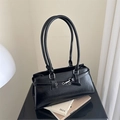 Bolso de hombro retro de cuero PU negro con hebillas plateadas en un estudio minimalista - Negro