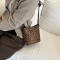 Borsa a secchiello leopardata alla moda con tracolla in pelle marrone indossata da modella - Leopardo Marrone