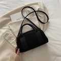 Bolso bandolera de ante negro con elegantes detalles dorados y asa cilíndrica - Negro