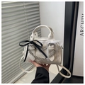 Dettaglio borsa crema con fiocchi in pizzo e raso e catena metallica decorativa trendy - Bianco