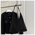 Macro shot of matte black suede tote bag detailing the silver FASHION letter engraving - Black